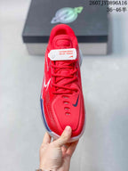 Top view of the red lace-up basketball shoe showing the padded tongue, eyelets and dark contrasting forefoot logo.