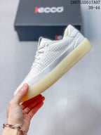 Side view of a white ECCO sneaker showing perforated panels, stitched details and the gum-colored outsole.