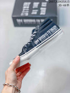 Side view showing the black upper, white contrast stitching and white sidewall sole.