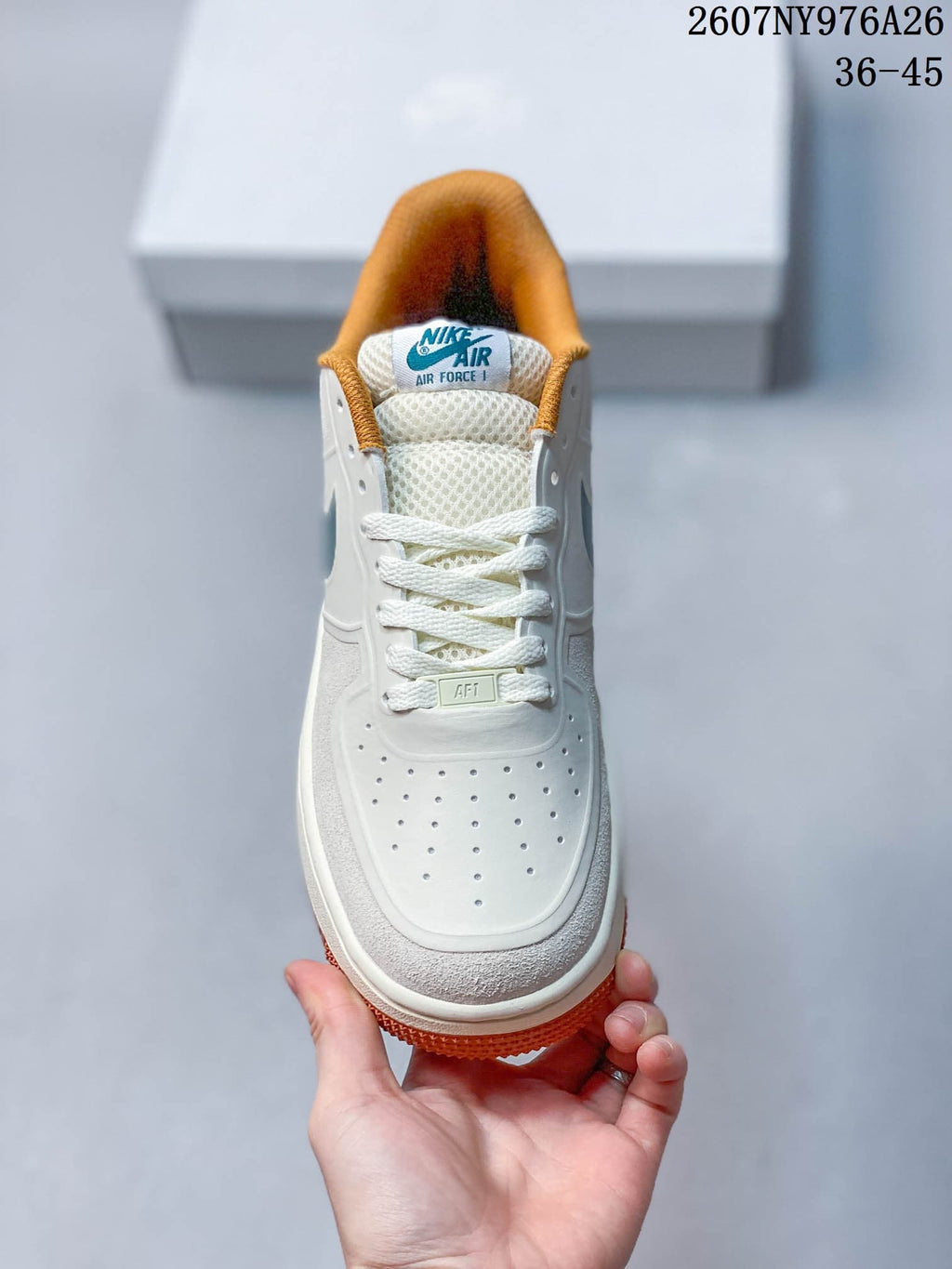 Top view of the sneaker showing the perforated white toe box, white laces, padded tongue, and orange collar lining.