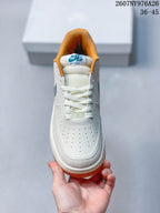 Top view of the sneaker showing the perforated white toe box, white laces, padded tongue, and orange collar lining.