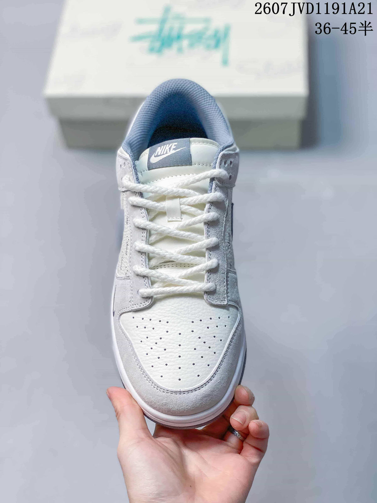Top view of the sneaker showing white laces, perforated toe box, blue-gray tongue label and padded collar.