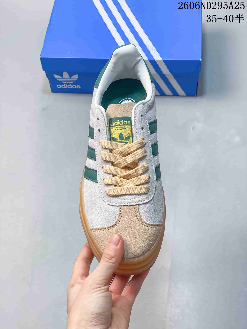 Top view of the sneaker showing cream laces, beige toe accents, green stripes, and tongue branding.