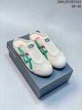 Pair of cream Onitsuka Tiger Mexico 66 Sabot slip-on sneakers with green and red side stripes displayed on a branded shoe box.