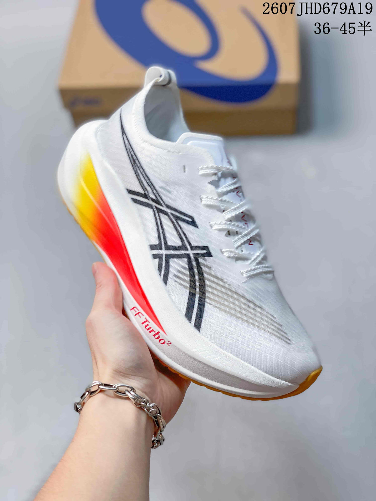 Close side view of the white ASICS running shoe showing the black logo, yellow-to-red heel accent, and FF TURBO 2 marking.