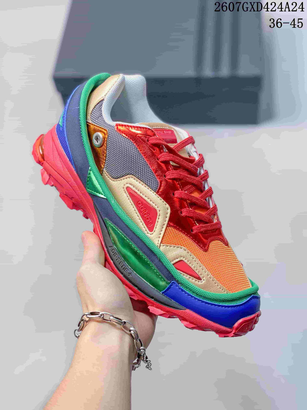 Close-up of a multicolor OZWEEGO sneaker featuring red, green, blue, orange, and gold-toned panels.