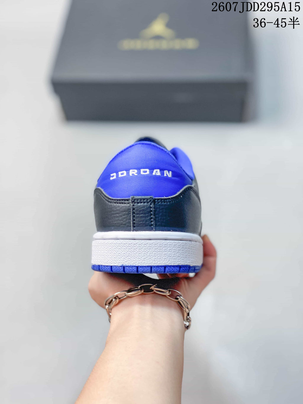 Rear view of the low-top sneaker showing blue collar lining, Jordan branding, a white midsole, and a blue outsole.