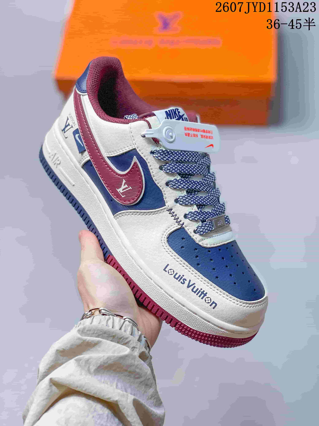 Angled side view showing the white, blue and burgundy color blocking, patterned laces and visible Louis Vuitton branding.