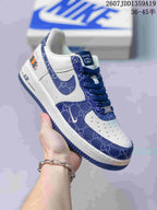 Close-up of a white low-top sneaker with blue patterned panels, blue Swoosh, blue laces, and a blue outsole; image text shows style code 2607JDD1359A19 and size range 36-45.