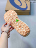 Close-up of the textured trail-style outsole with raised tread elements and a green outsole insert.