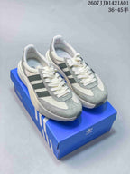 Adidas Adizero SL 72 Pro sneakers in off-white and grey shown on a blue box