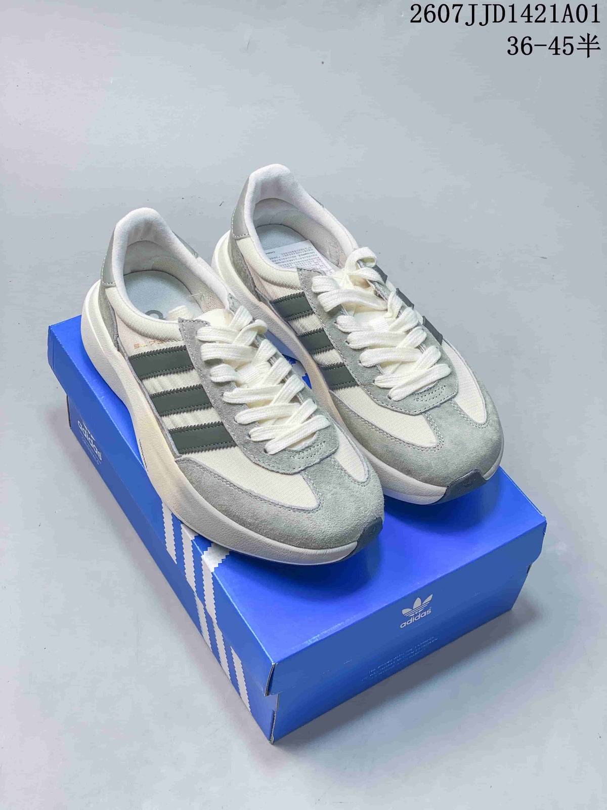 Adidas Adizero SL 72 Pro sneakers in off-white and grey shown on a blue box