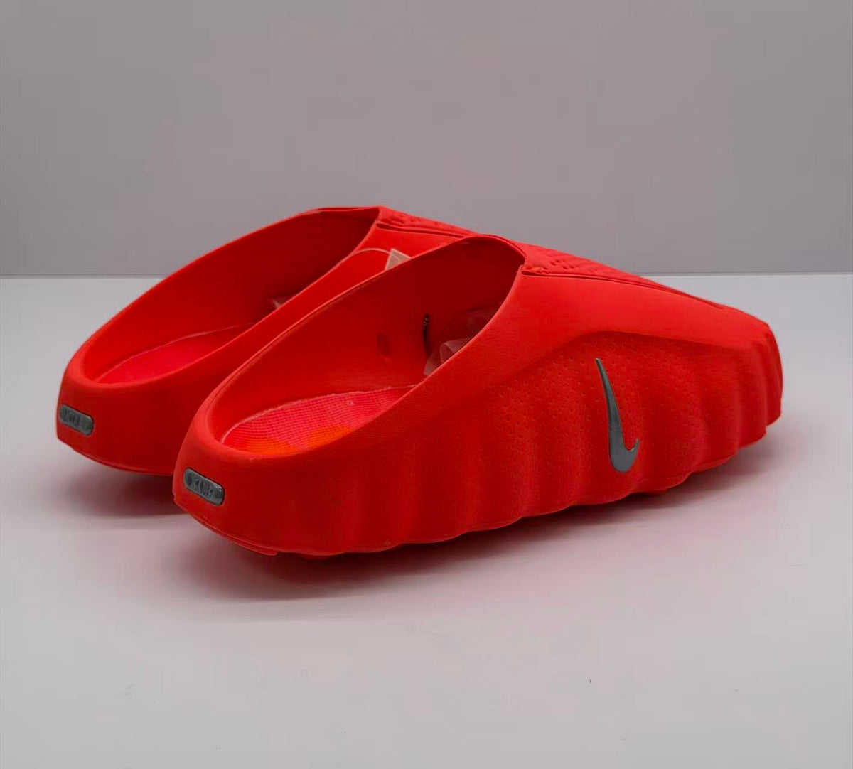 Rear three-quarter view showing the open heels and side branding on the slides.