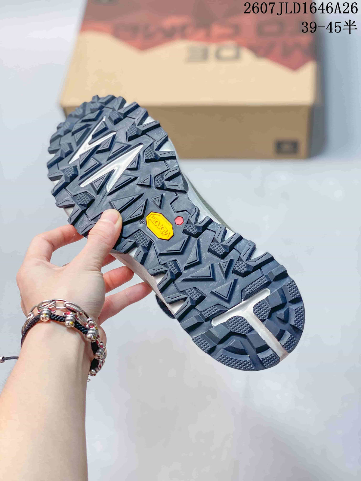 Close view of the shoe outsole showing a deep lug pattern, geometric tread sections, and a visible Vibram mark.
