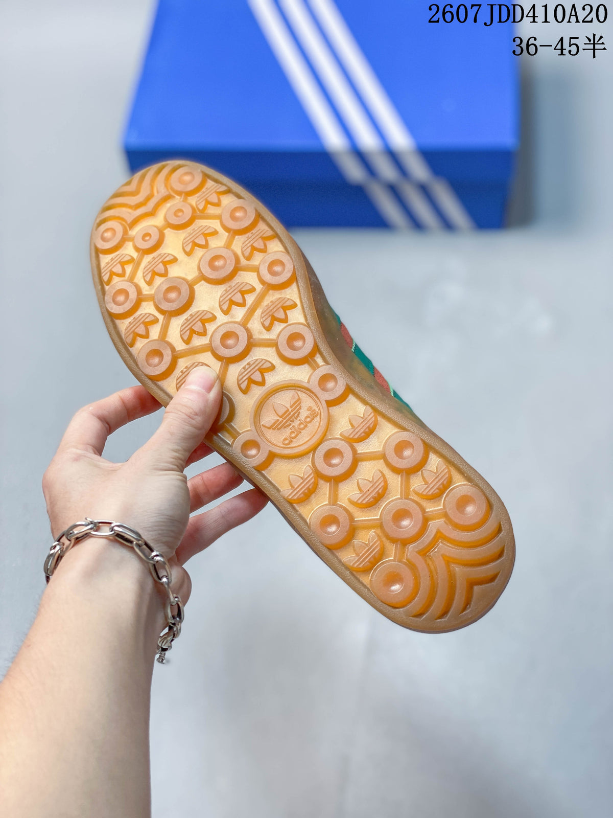 Underside view showing the translucent gum-colored outsole with circular textured tread and adidas branding.