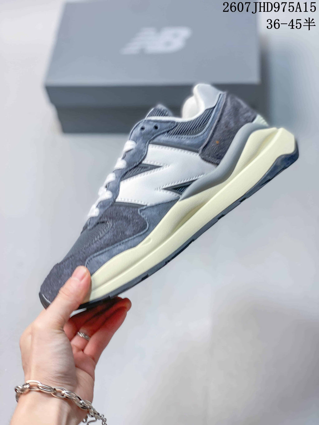 Side profile of the grey and white New Balance 5740 sneaker with its layered panels and cream-colored midsole.