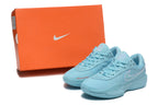 Light-blue Nike G.T. Cut Academy shoes displayed beside an orange Nike shoebox