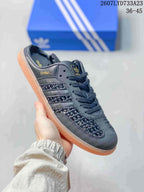 Close-up side view of a black adidas Samba OG mule-style sneaker with woven side panels, lace-up closure, and gum-colored outsole.