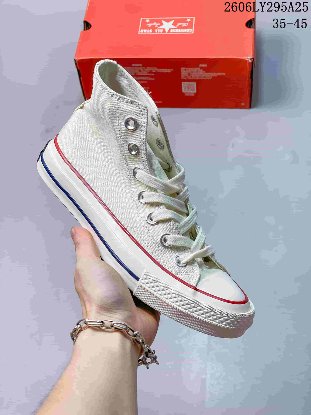 White high-top sneaker with red and blue trim, white laces, and a rubber toe cap; size range 35–45 is printed in the image.
