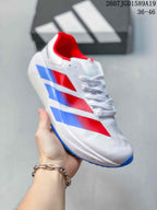 Close side view of the white adidas training sneaker showing blue and red side accents, laces, and blue outsole edges.