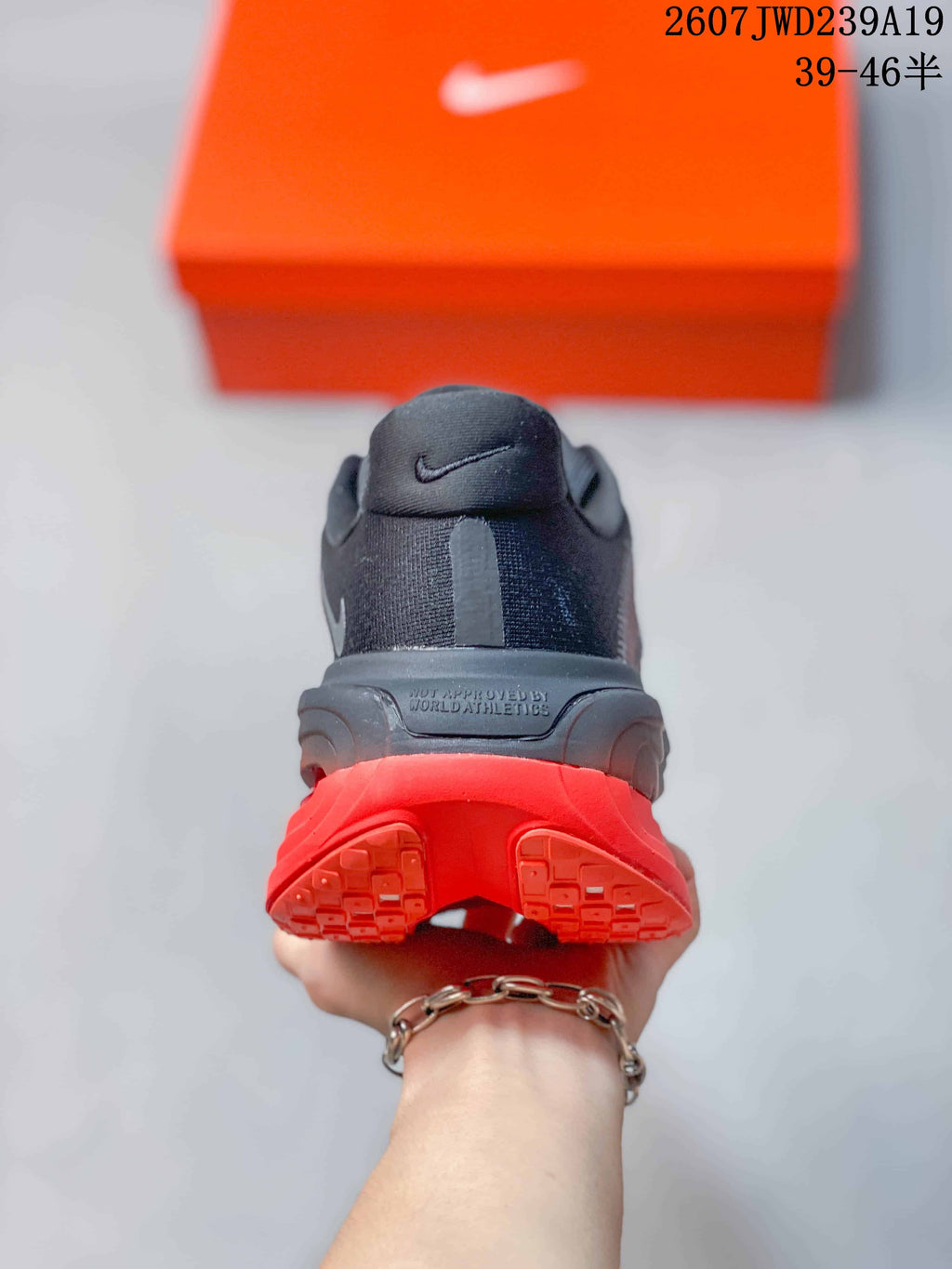 Rear view showing the padded heel, dark upper, and split red outsole design.