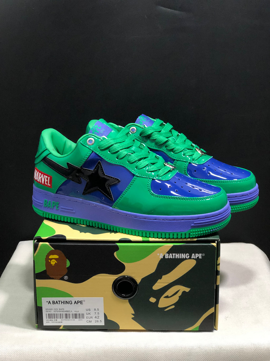 Pair of green, blue and purple Bape Sta low-top sneakers displayed on a camouflage-patterned box; the box label shows EU 42 and 26.5 cm.