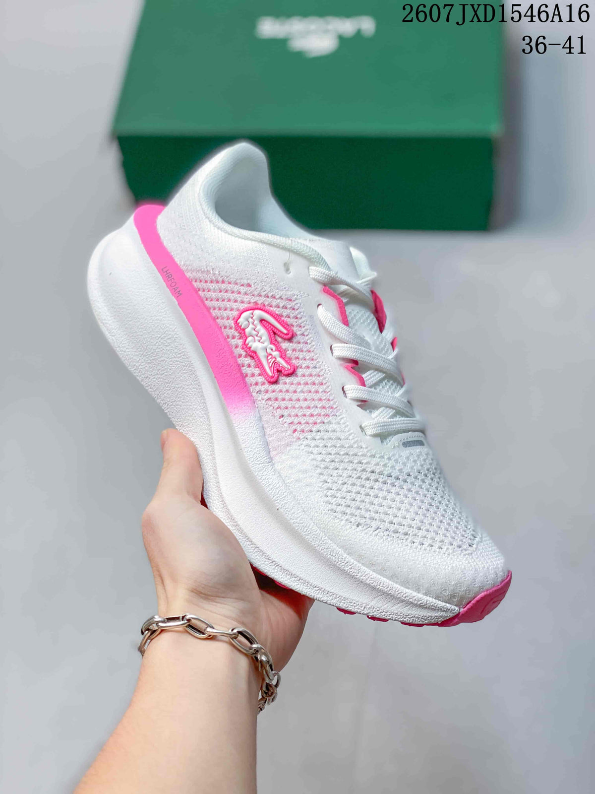 Angled side view of the white and pink sneaker with visible Lacoste branding and pink outsole.