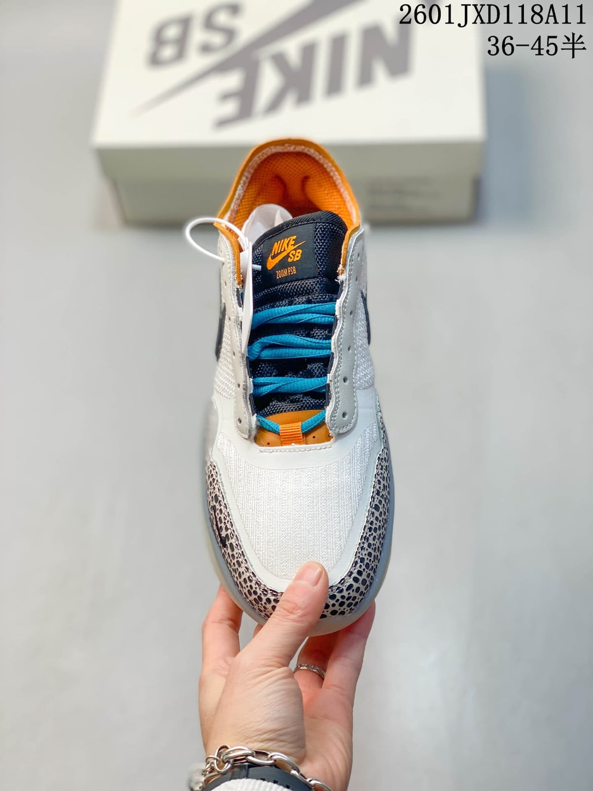 Top view of the Nike SB PS8 sneaker showing the white toe area, blue laces, dark tongue and orange details.