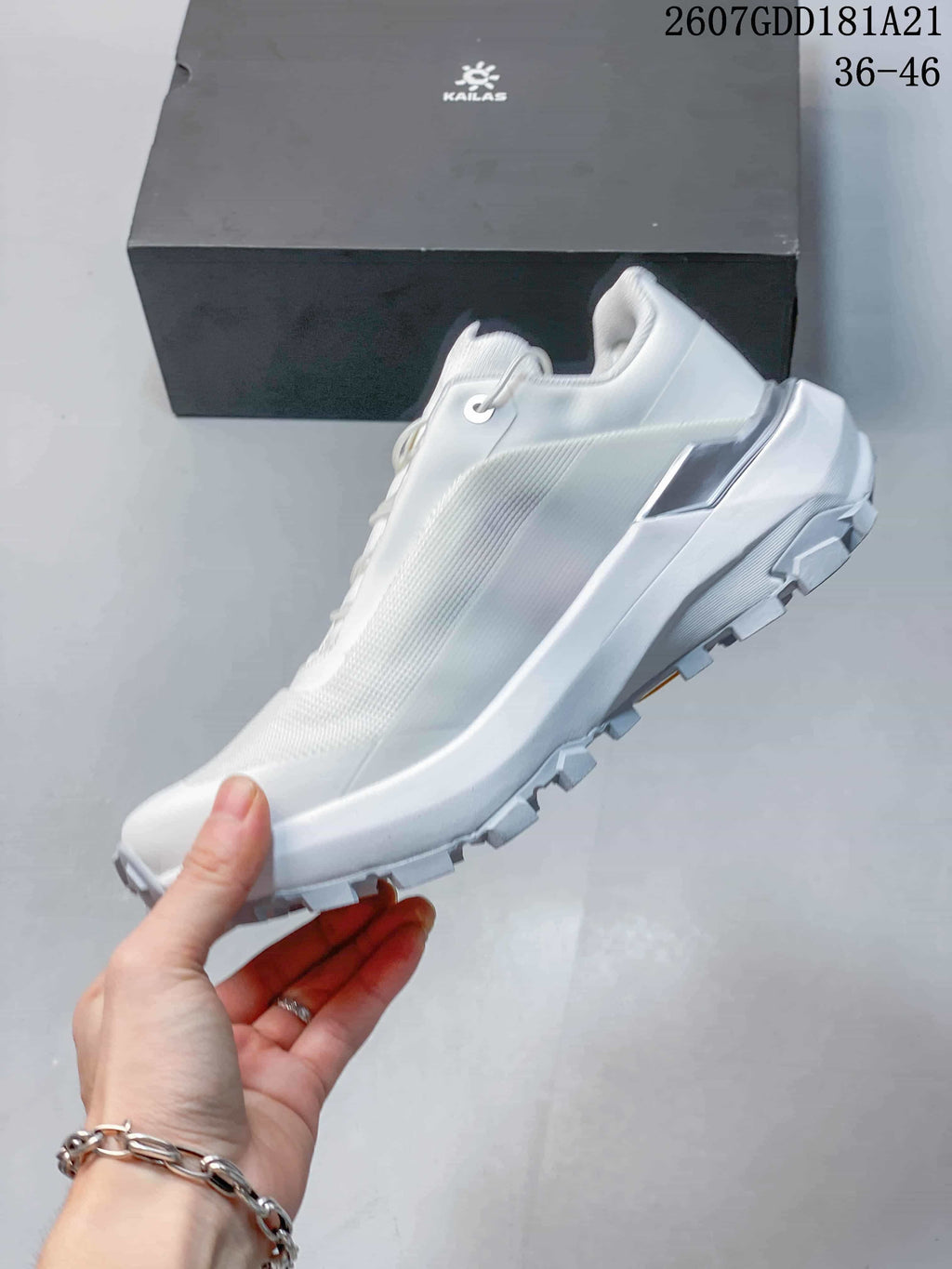 Side view of the white low-top shoe showing the streamlined upper, raised heel section and lugged outsole.
