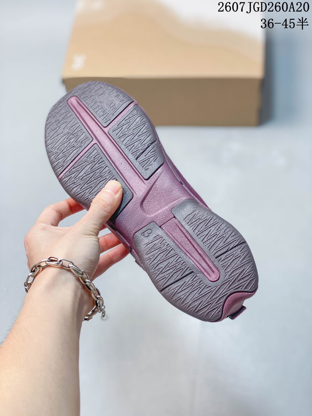 Underside view of the plum-purple sneaker showing segmented outsole panels with textured traction surfaces.