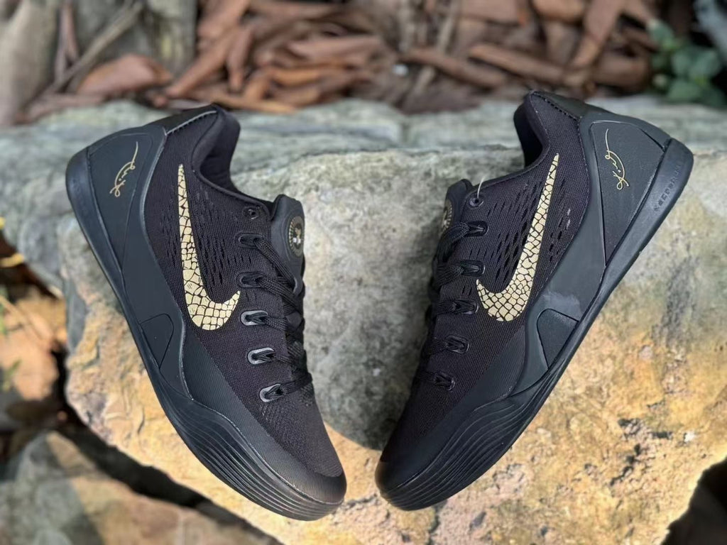 Top view of a pair of black Kobe 9 shoes with gold-toned Swoosh graphics.