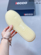 Close view of the textured translucent gum-colored outsole of a white ECCO sneaker.