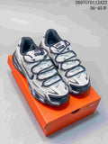 Pair of white and black Nike sneakers displayed on an orange shoebox, showing layered panels and dark laces.