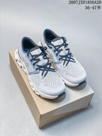 Pair of light gray and white On Cloud X 4 sneakers with navy laces displayed on a shoe box.