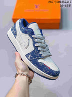 White and denim-blue low-top sneaker with monogram-style patterned panels, white laces and a dark blue outsole.