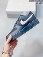 Side profile of the black sneaker with a contrasting white Swoosh and low-top construction.