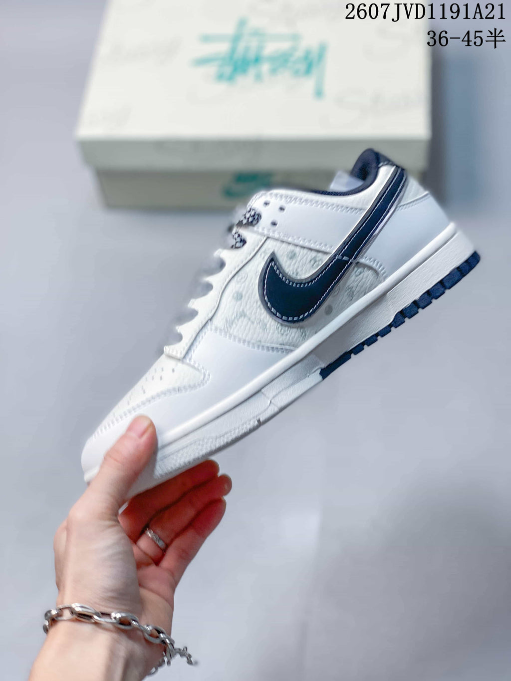 Side profile showing the dark Swoosh, printed side panel, white midsole, and dark outsole edge.