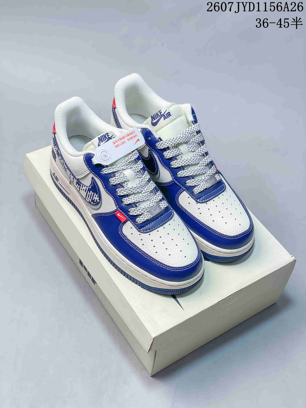 Pair of white and blue Nike Air Force 1 low-top sneakers displayed on a shoebox.