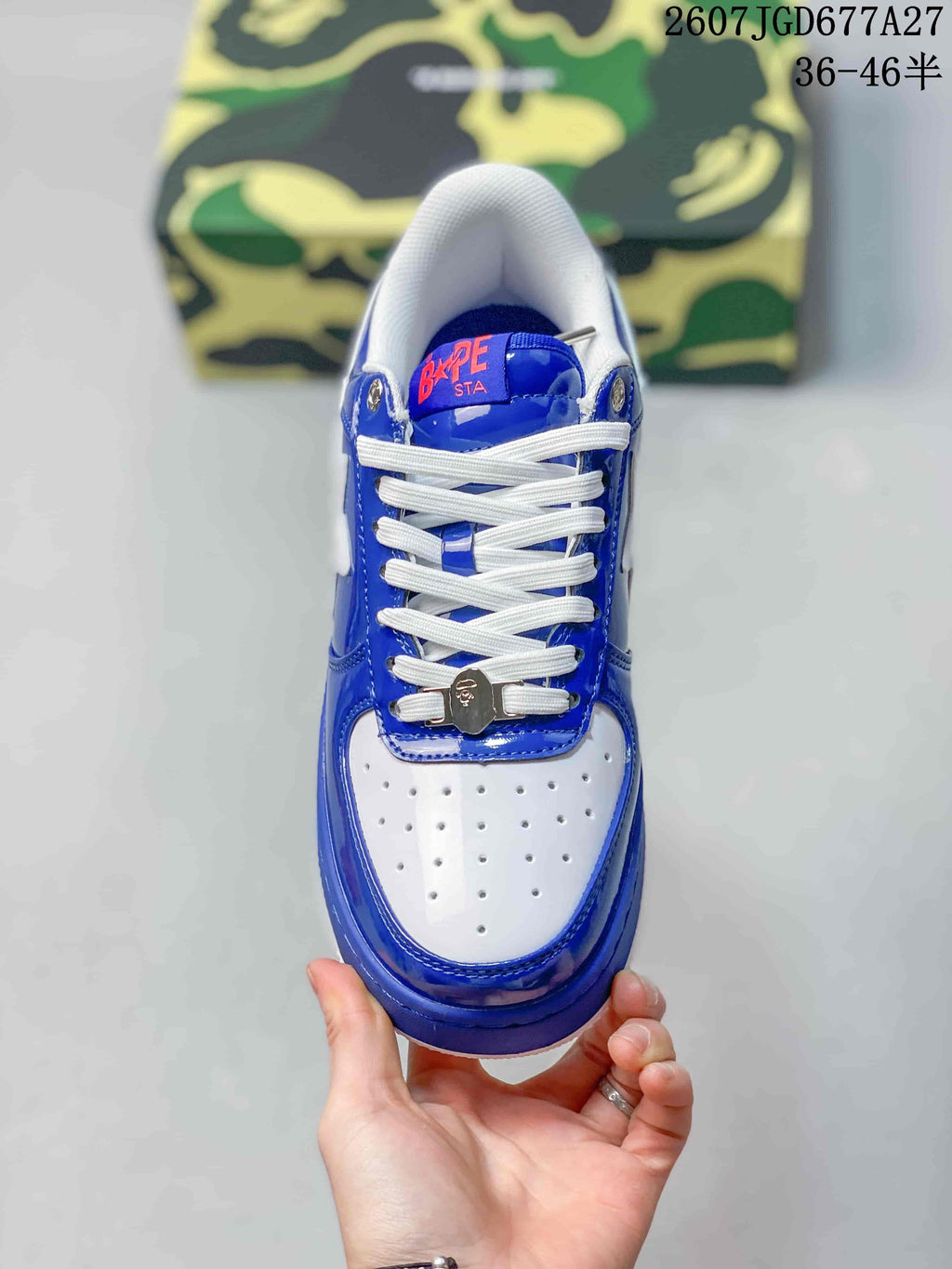 Top view of a blue and white sneaker with a perforated white toe box, white laces, and a decorative lace accessory.