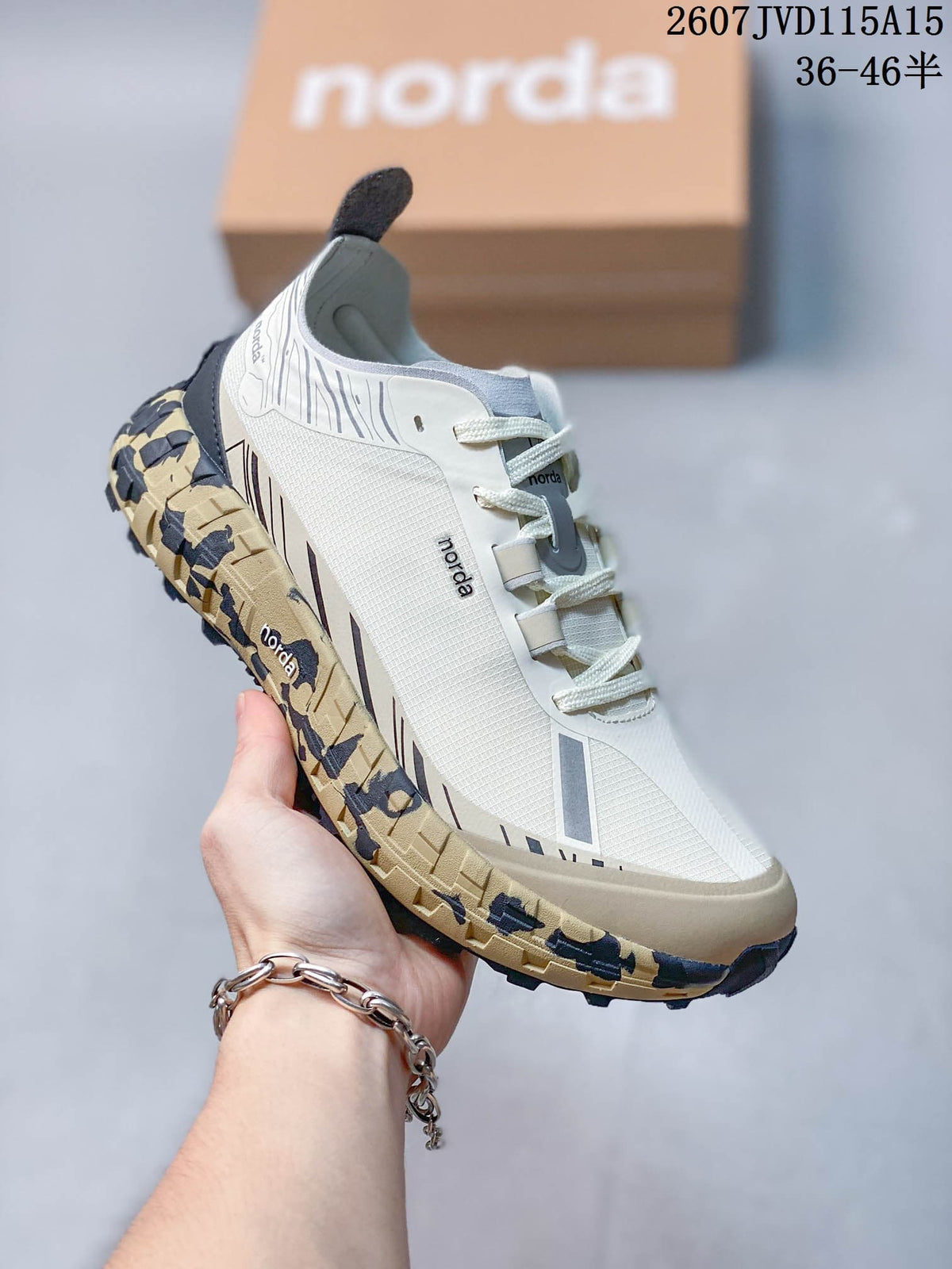 Close side view of a white NORDA sneaker with mesh-look panels, layered overlays, padded collar and lugged outsole.