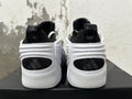 Rear view of white and black sneakers with sculpted heels and black heel panels