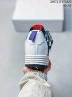 Rear view showing the white heel structure, layered midsole, dark outsole, and purple heel pull tab.