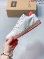 Side view of the white low-top sneaker showing the perforated upper, cream laces and red outsole edge.