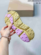 Underside view of an On CloudSoma sneaker showing the segmented yellow and pink lugged outsole.