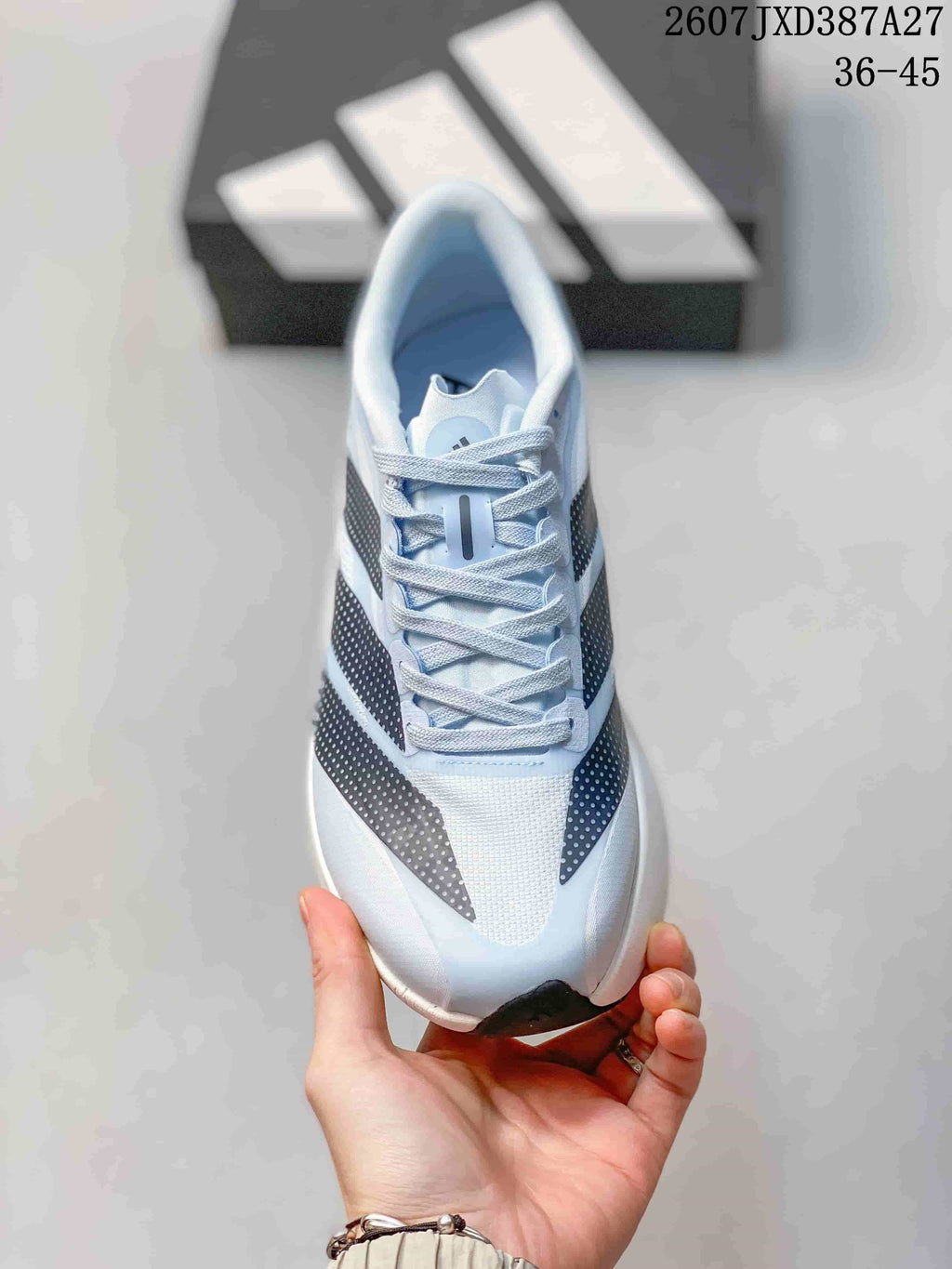 Top view of the light blue lace-up shoe showing the tongue, laces, mesh-like toe area, and contrasting side stripes.