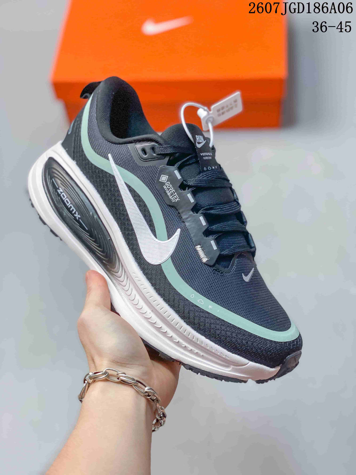Three-quarter side view showing the dark navy upper, mint overlays, white swoosh, ZoomX marking, and sculpted white midsole.