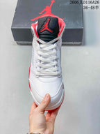 Front view of the white high-top sneaker with black and red tongue detailing