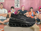 Side view of a black On Running sneaker showing the gray logo band and sculpted sole.