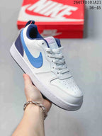 White Nike Court Borough BG sneaker with blue and navy accents, shown from the side.