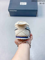 Rear view showing the layered heel construction, cream upper, pale blue detail, and textured outsole.